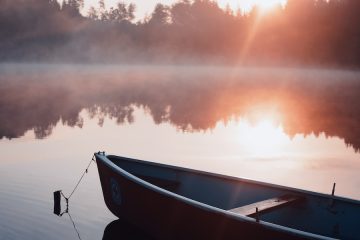 white and black boat on water during sunset