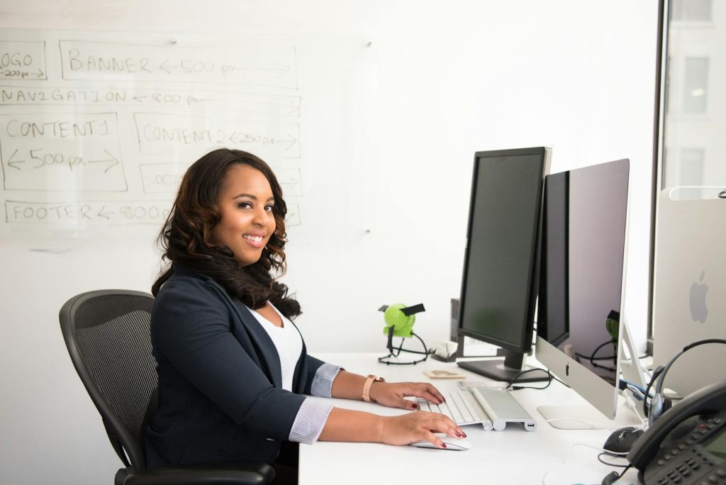 Woman in Professional Wear Seated in front of Monitor